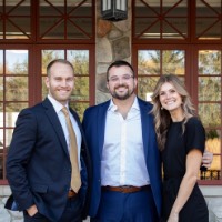 Alex Hogarth poses with 2 other people outside of Alumni House